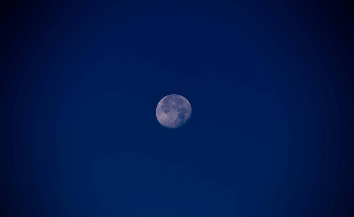 A full moon is seen in the night sky